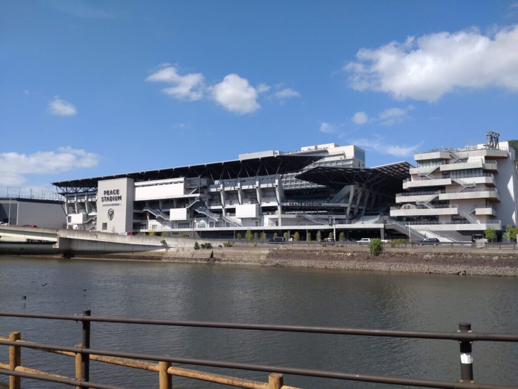川の対岸から見たスタジアムシティ。アリーナ、スタジアム、商業施設が見える